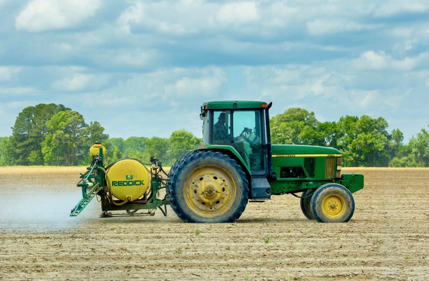 Photo of a Green and Yellow Tractor on Dirt