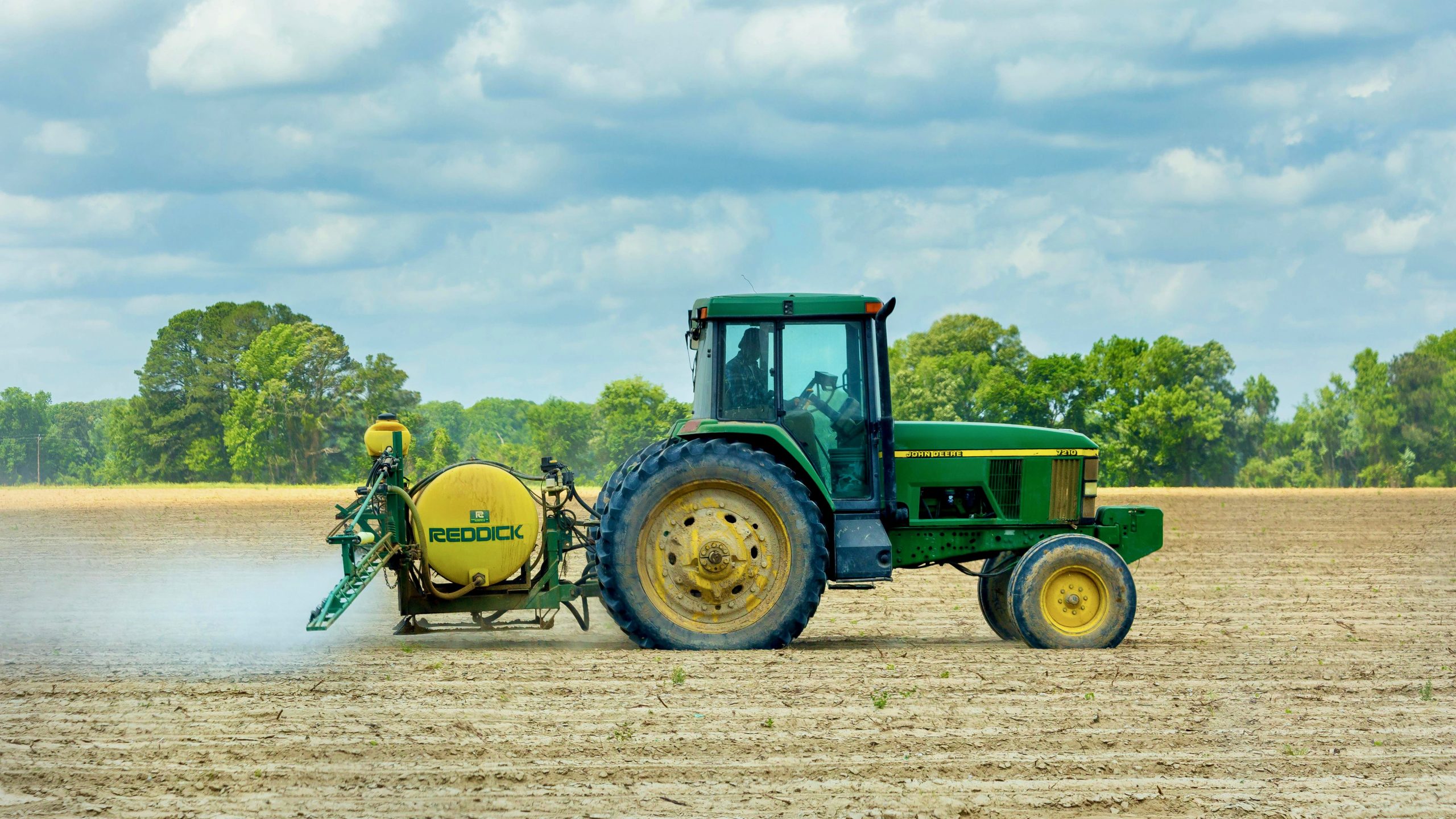 Photo of a Green and Yellow Tractor on Dirt