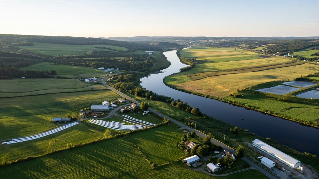 Photo of Aerial View of Quebec Countryside and farm next to a meandering river.