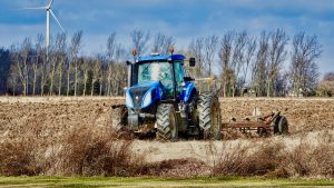Photo of a blue tractor plowing a field in Ontario, Canada.