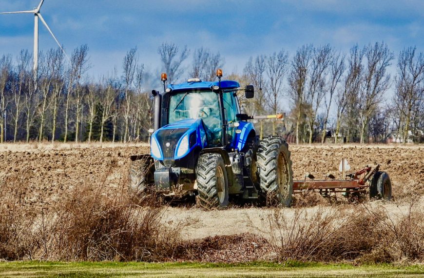 Photo of a blue tractor plowing a field in Ontario, Canada.